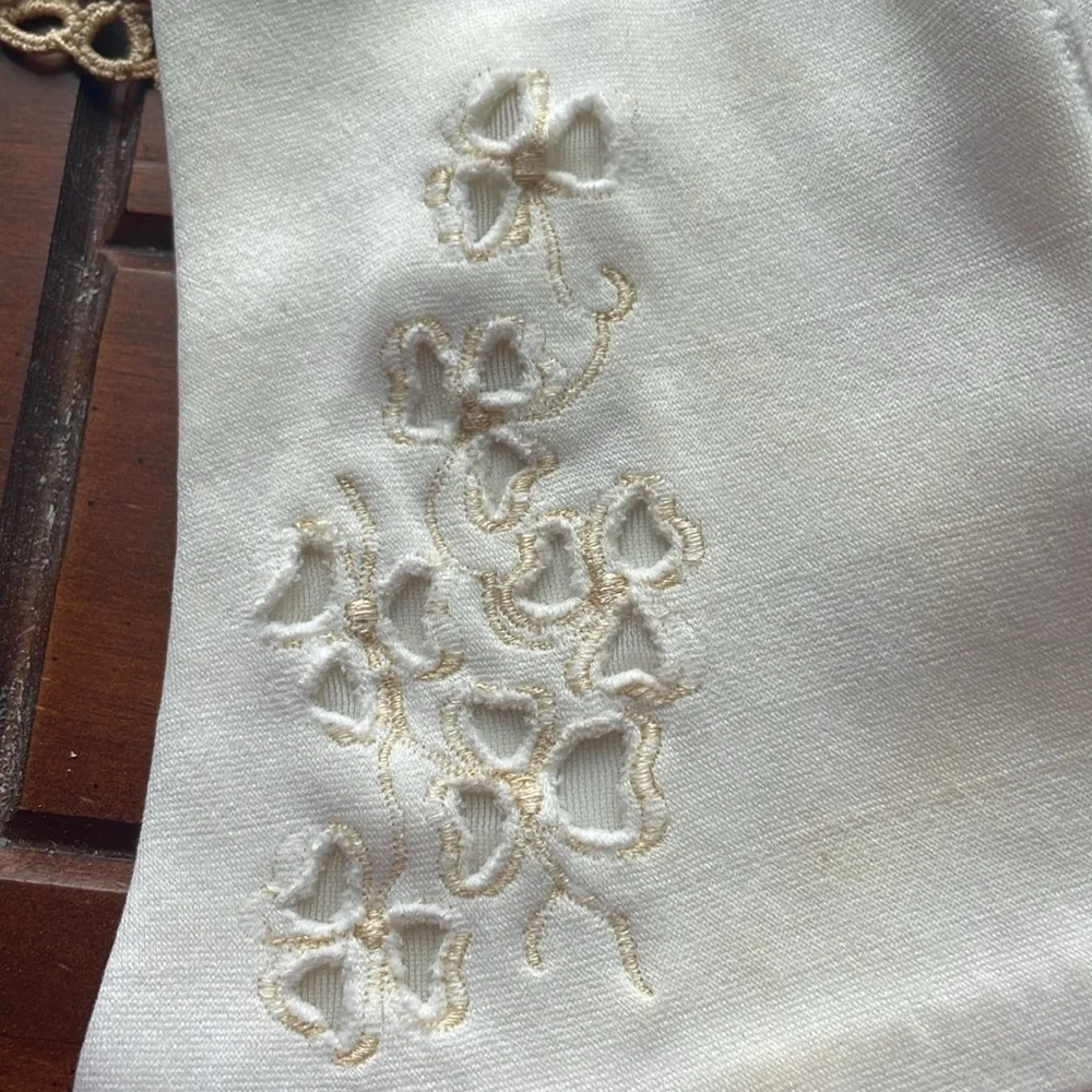 Beautiful delicate vintage white gloves with floral accents.